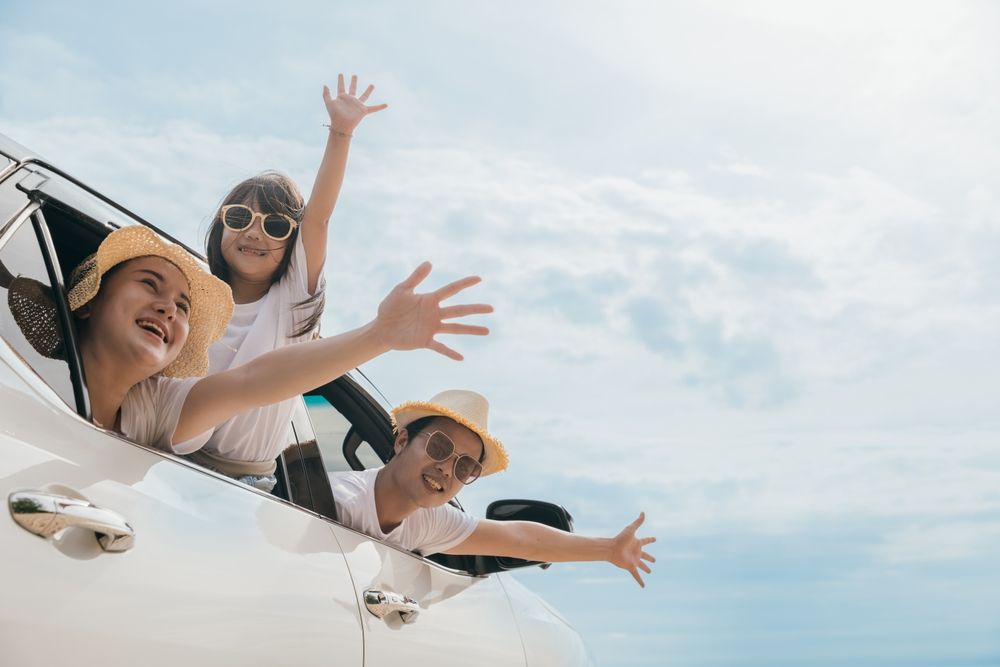 A family is looking out of the window of a car.