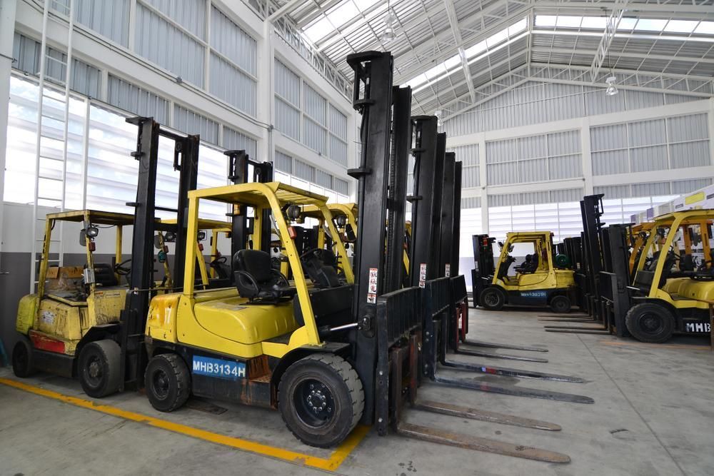Row of Forklifts Are Parked in a Warehouse — Bundaberg Forklift Repairs Hervey Bay, QLD