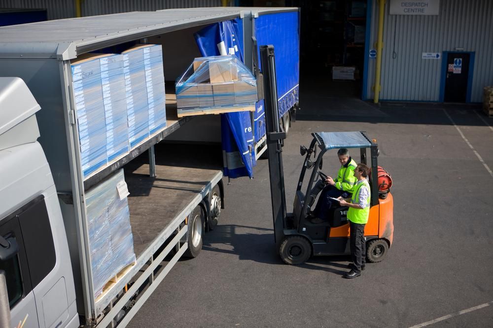 Two Men Are Loading a Truck With a Forklift — Bundaberg Forklift Repairs Agnes Water, QLD 