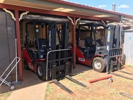 Two forklifts are parked under a canopy in a garage — Bundaberg Forklift Repairs Bundaberg North, QLD