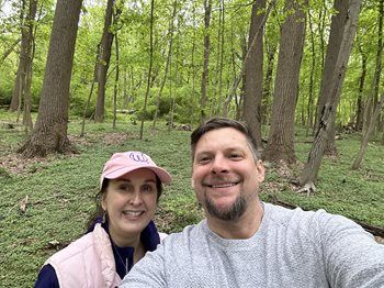 Dr. Yusavitz and Dr. Swatski taking a selfie in a green wooded park with tall trees