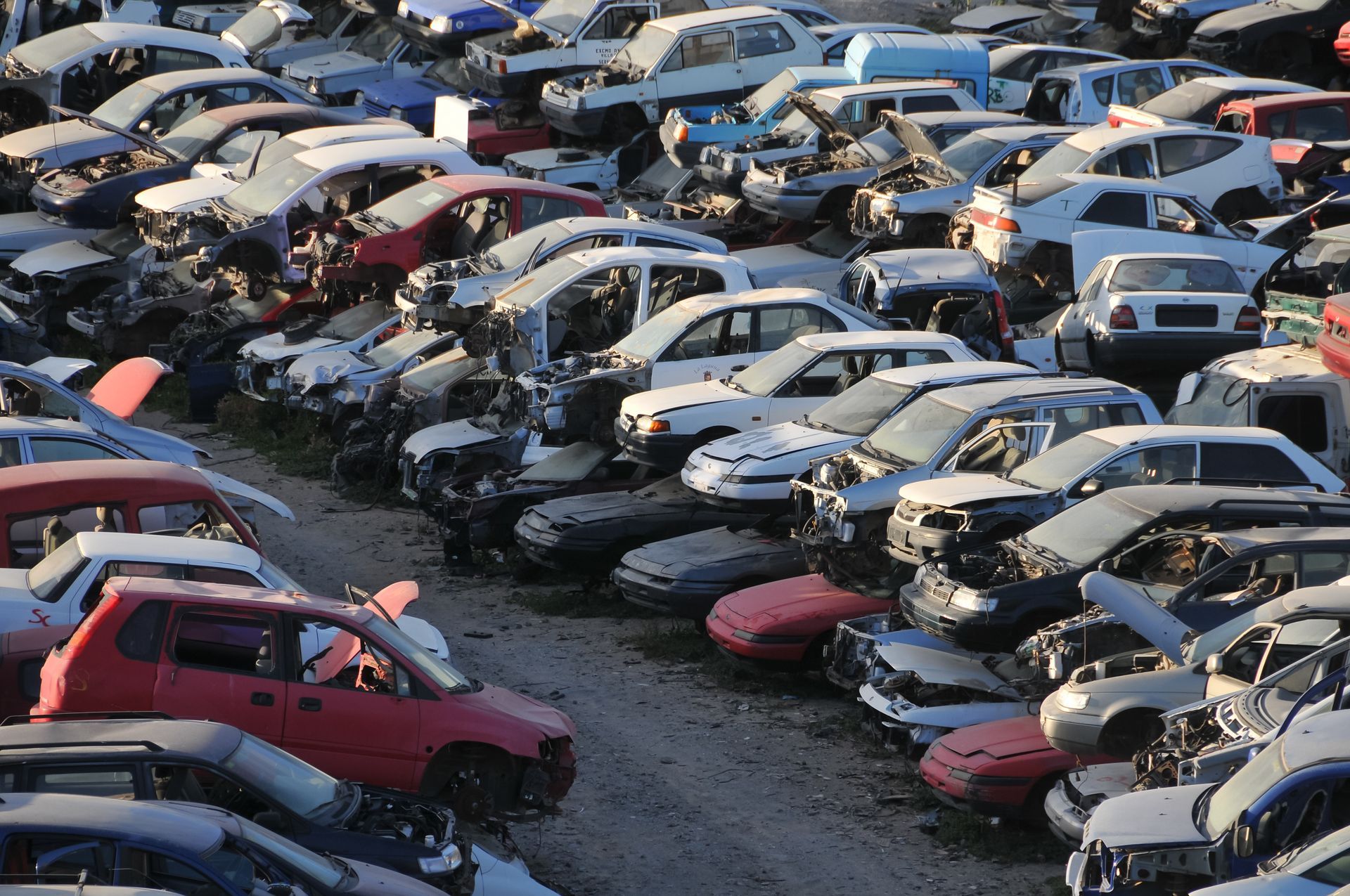 Salvage yard filled with damaged and dismantled vehicles awaiting recycling. Salvage yard filled with damaged and dismantled vehicles awaiting recycling.