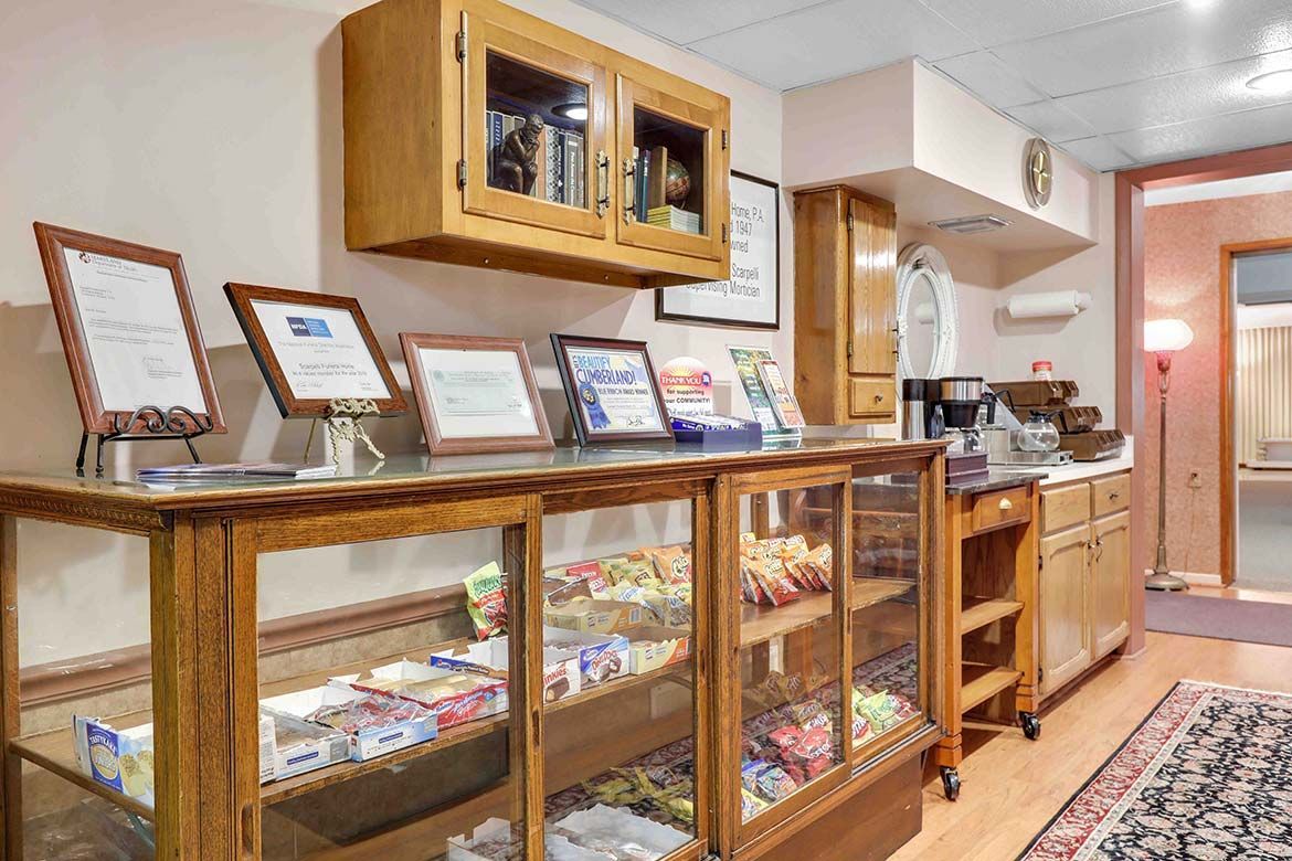 Bakery display case with assorted pastries and framed signs in a bright, cozy shop interior