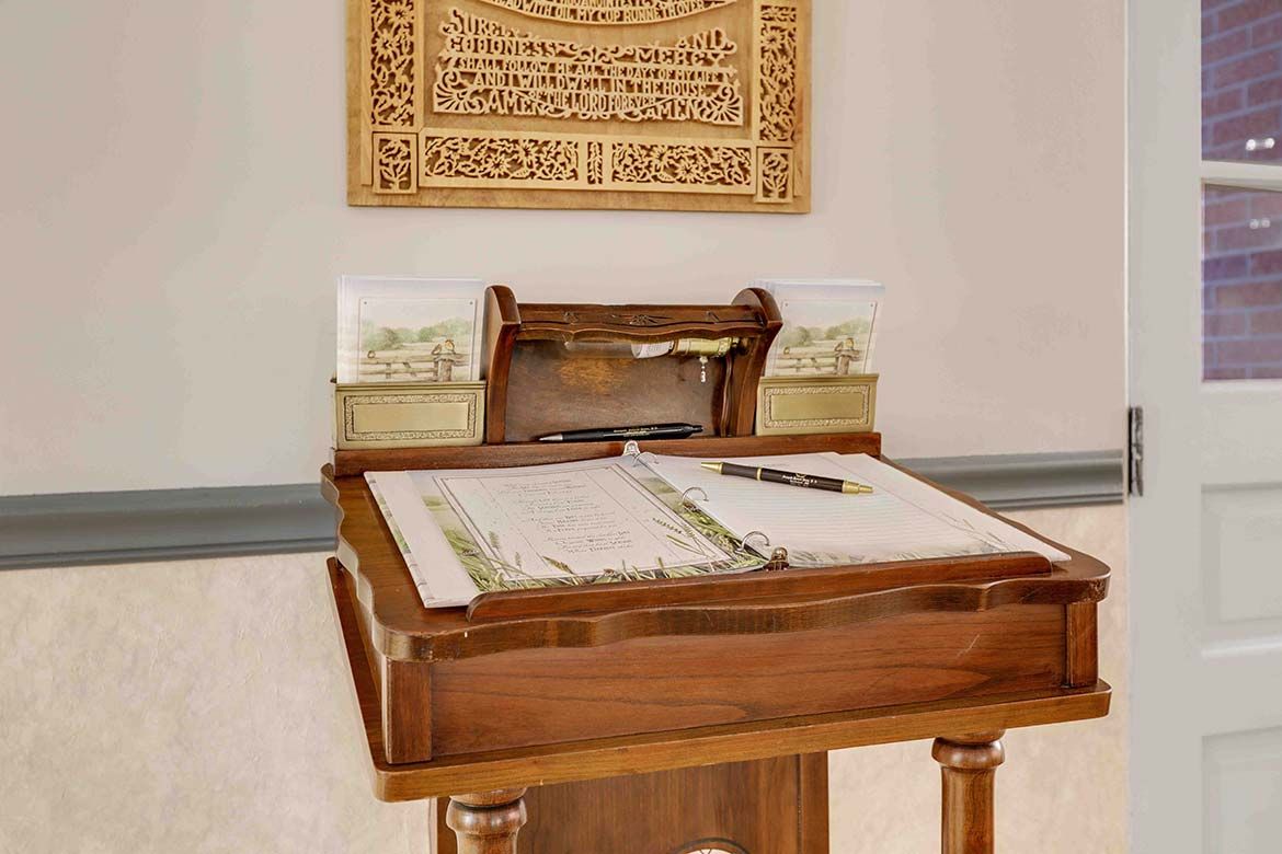 Framed display of an open manuscript on a stand in a museum or library exhibit