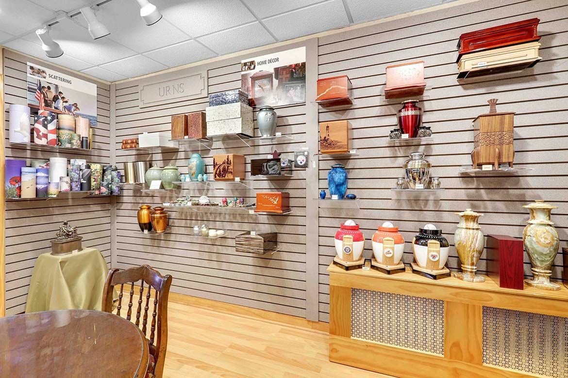 Display room with wall shelves of decorative household items and small furniture on a wood floor