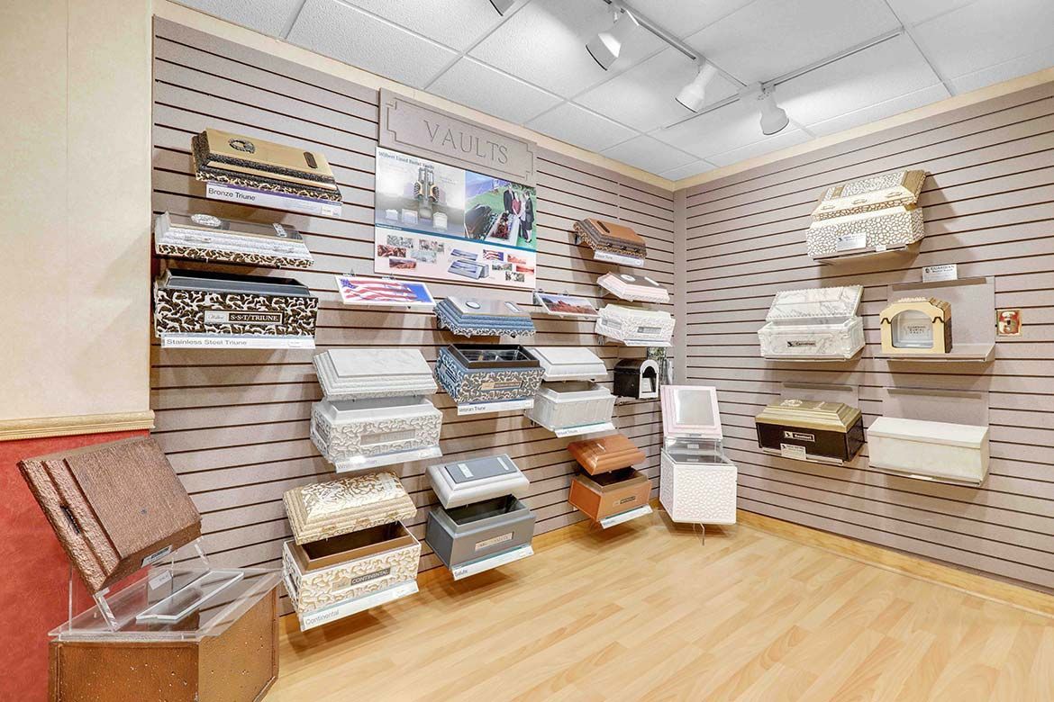 Display room with shelves of folded linens and bedding on pegboard walls and wood floor