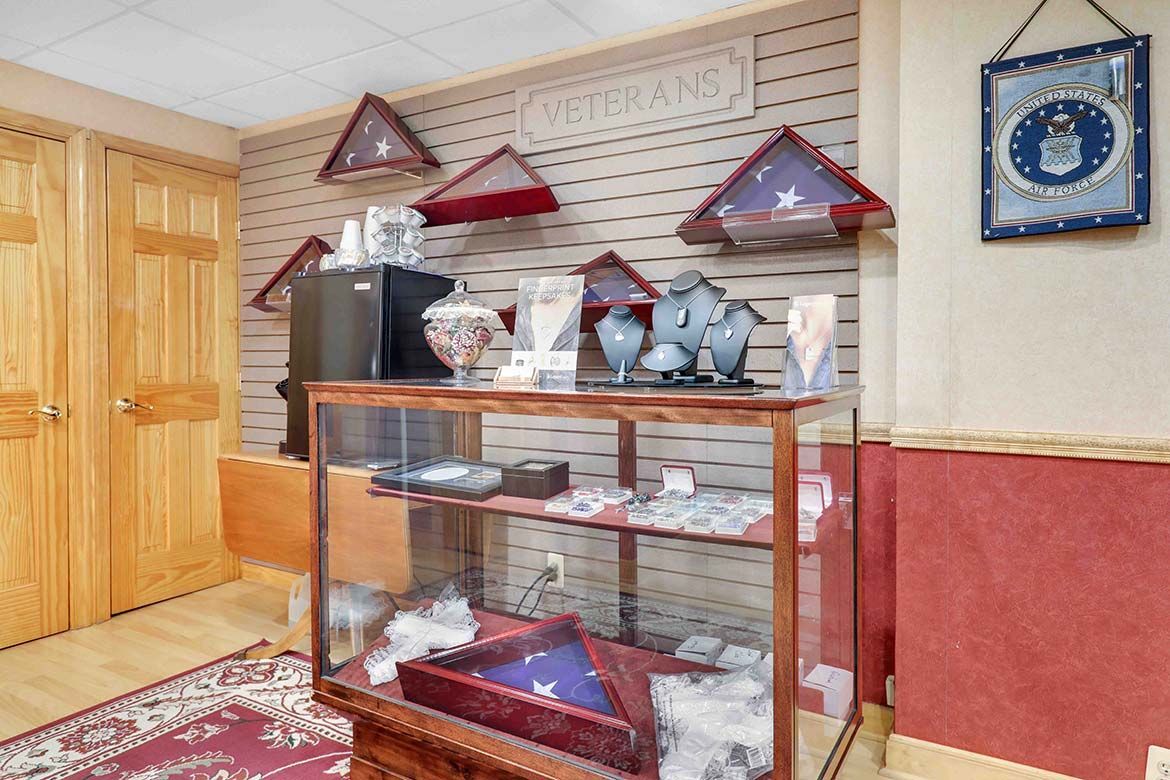 Wood-paneled room with a glass display case of trophies, triangular plaques, and blue wall clock