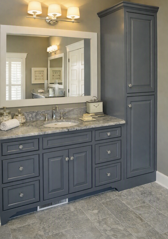 Gray bathroom vanity with granite countertop, large mirror, and tall cabinet under wall sconces