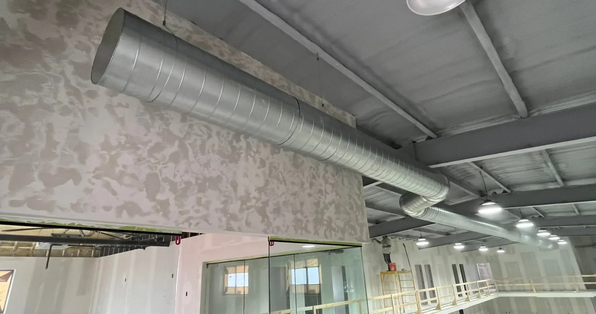 Air Fair Heat and Air LLC - A large metal pipe is hanging from the ceiling of a building.