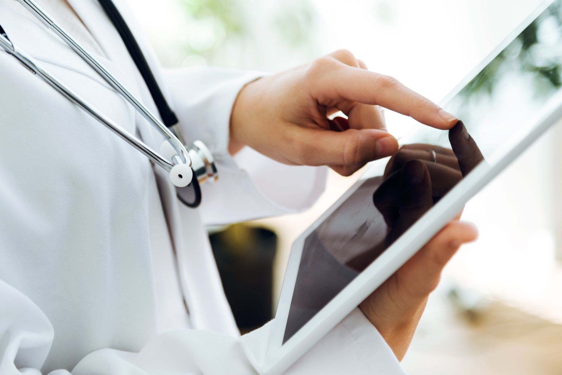Portrait of female doctor using her digital tablet in the office