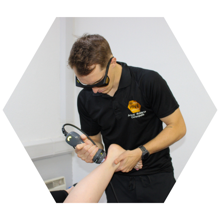 Arwel Roberts Osteopath using our lightforce deep tissue laser on an achilles tendon