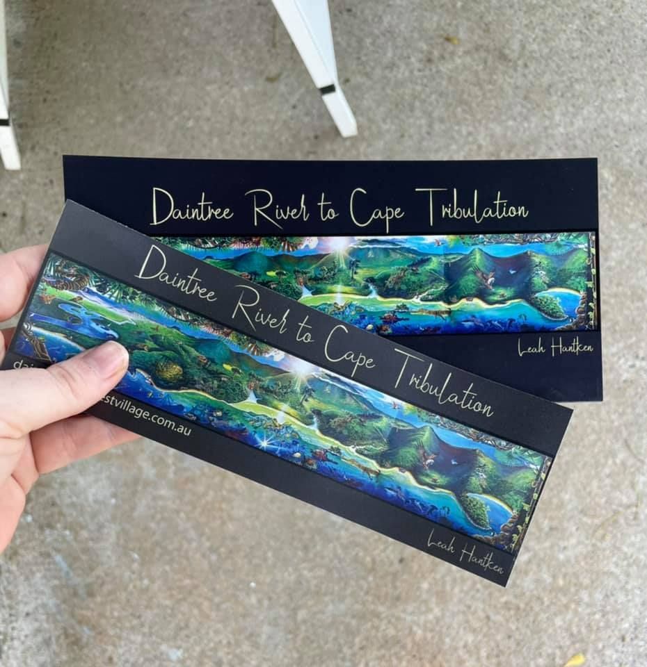 A person holds two identical art prints titled