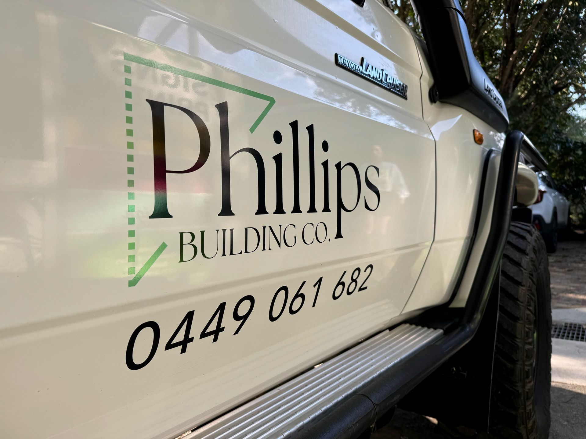Phillips Building Co. Logo and Phone Number on a White Vehicle Door — On The Spot Signs Port Douglas In Port Douglas, QLD