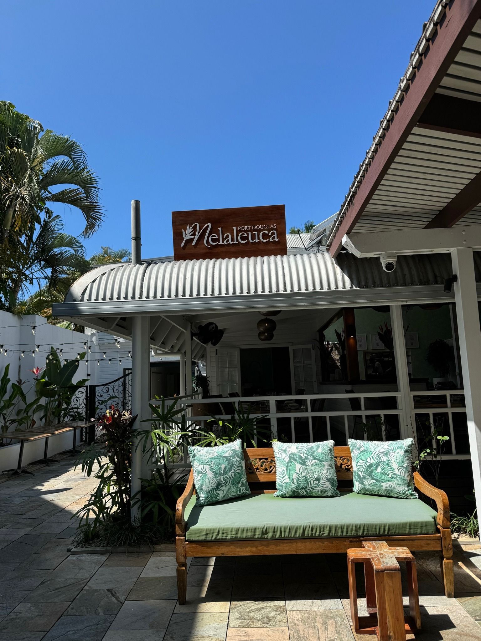 Restaurant Exterior With Wooden Bench and Decorative Pillows — On The Spot Signs Port Douglas In Port Douglas, QLD