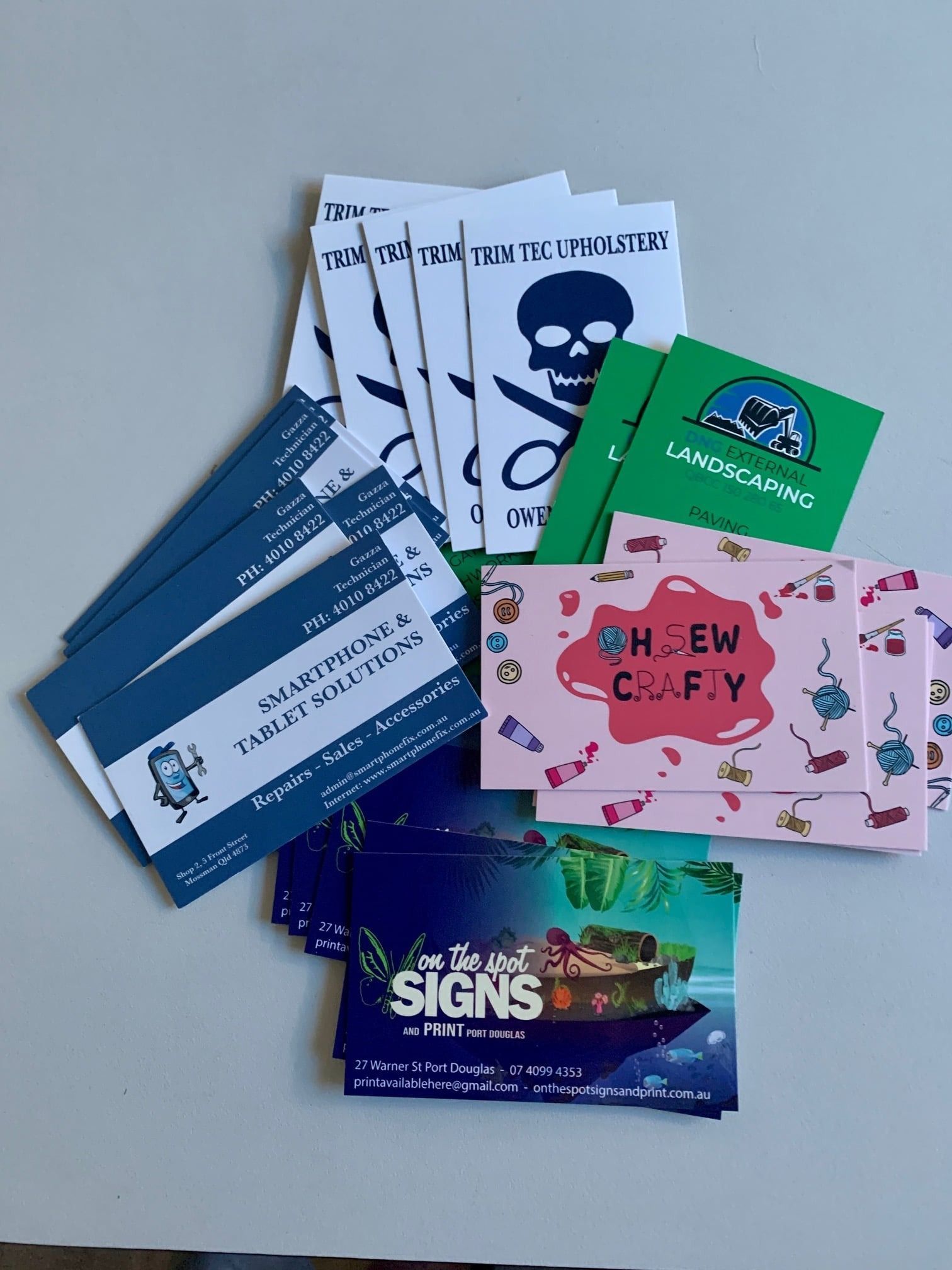 Stack of Business Cards and Promotional Materials — On The Spot Signs Port Douglas In Port Douglas, QLD