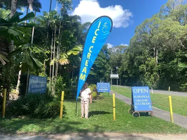 Blue Ice Cream Flag Near a Sign, Person, and Path — On The Spot Signs Port Douglas In Port Douglas, QLD
