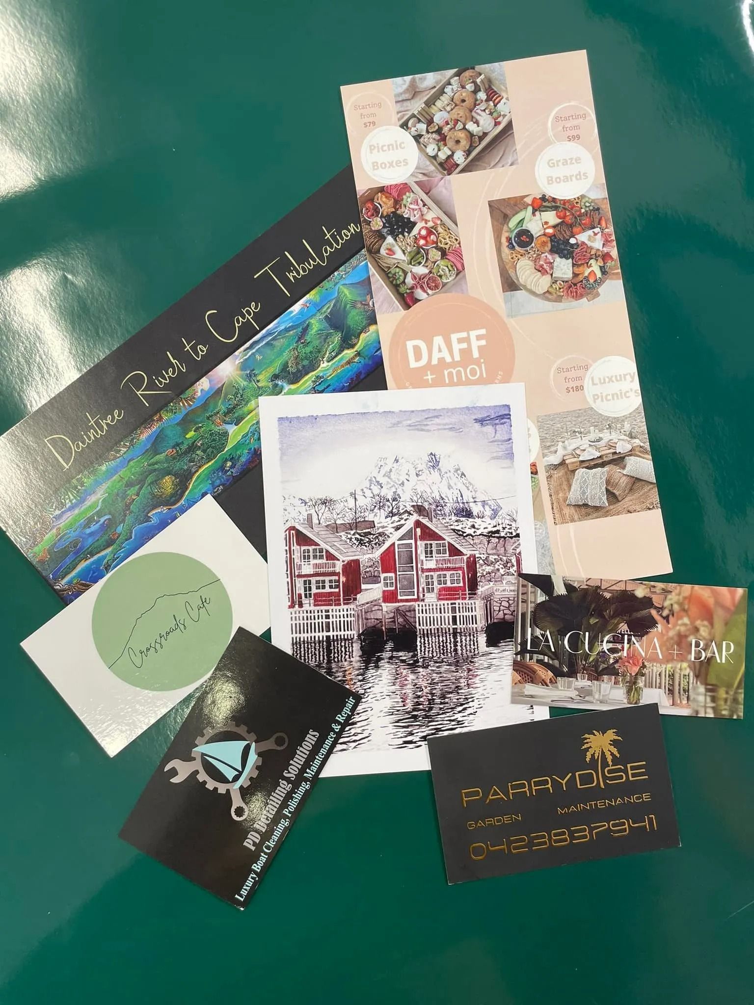 Assorted Cards and Leaflets on a Green Surface — On The Spot Signs Port Douglas In Port Douglas, QLD