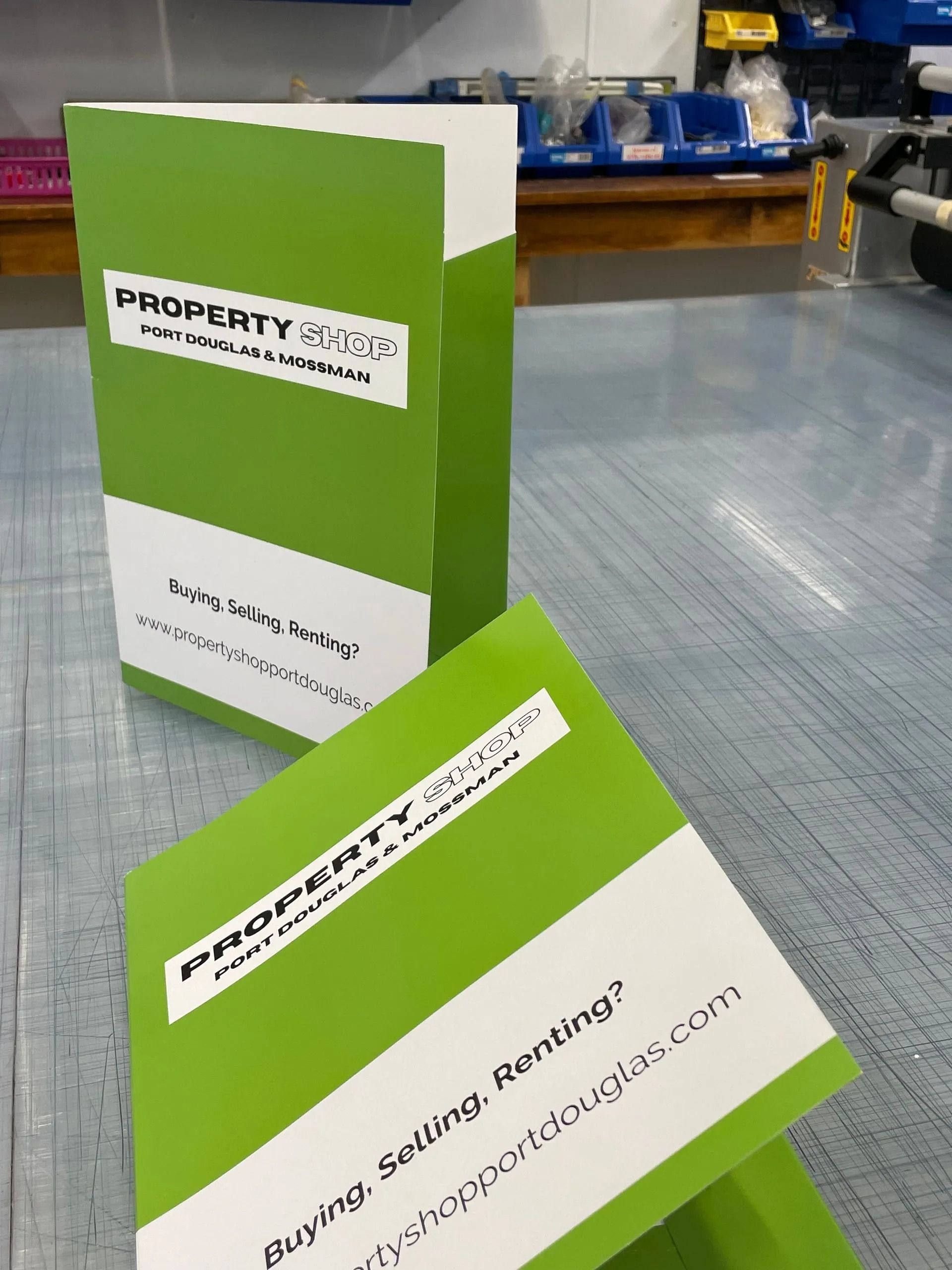 Two Green and White Property Usa Business Cards on a Blue Surface — On The Spot Signs Port Douglas In Port Douglas, QLD
