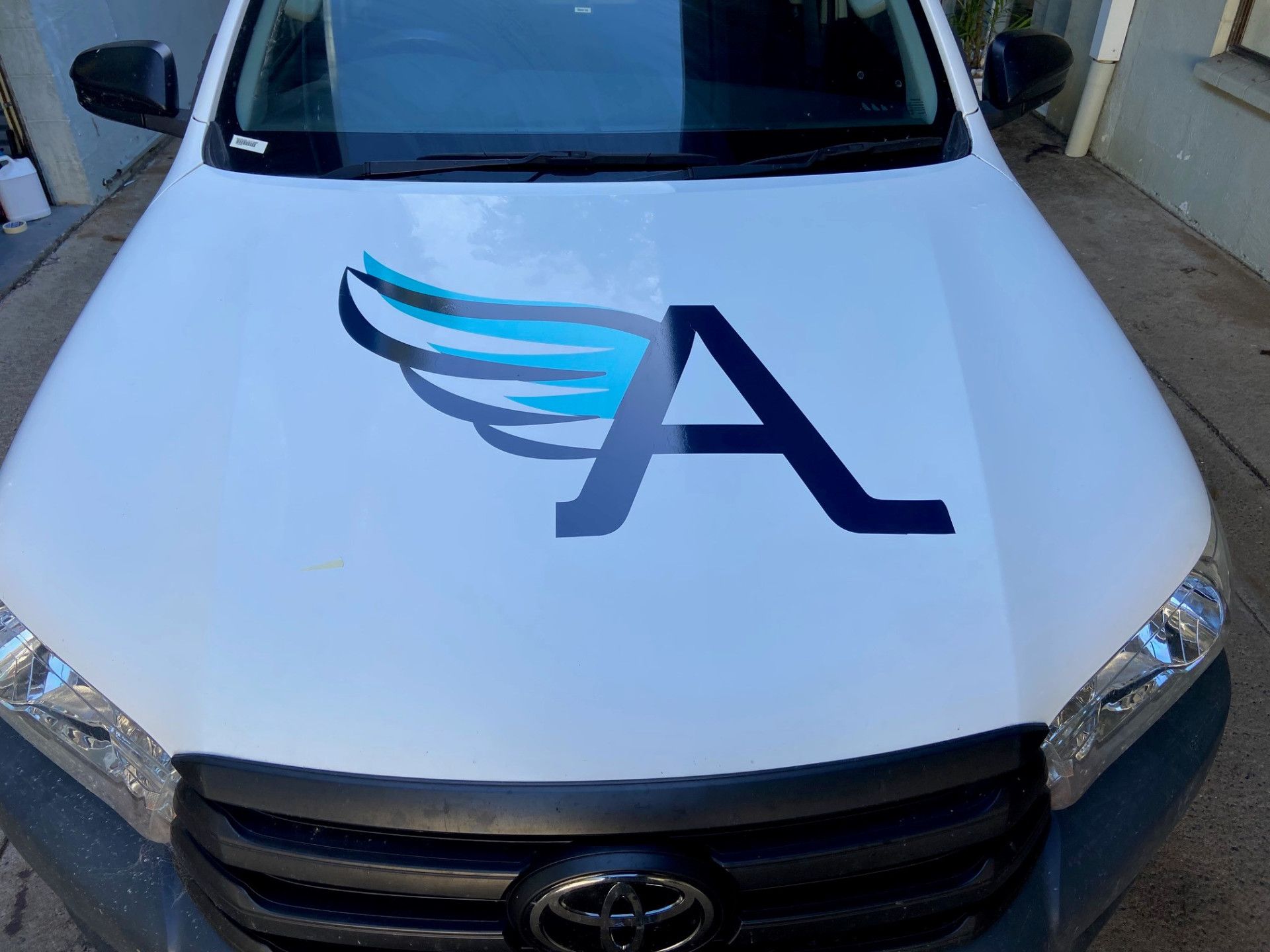 A Toyota Hood Features a Large Blue Letter A With Stylized Wings — On The Spot Signs Port Douglas In Port Douglas, QLD