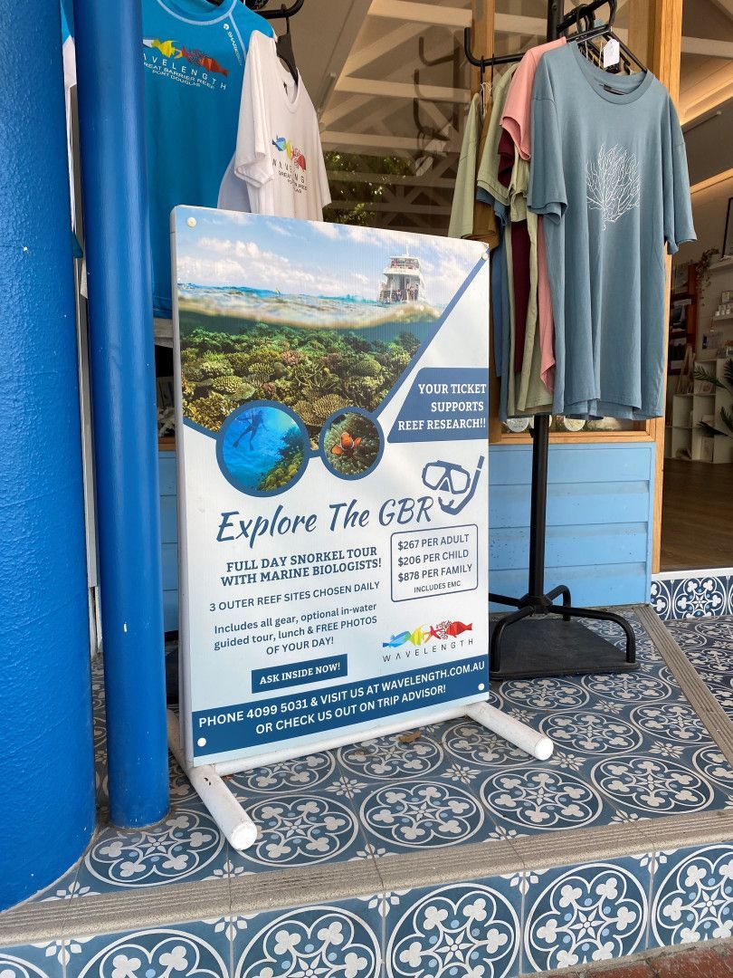 A Sign Promoting Great Barrier Reef Tours Featuring Clothing on Racks — On The Spot Signs Port Douglas In Port Douglas, QLD