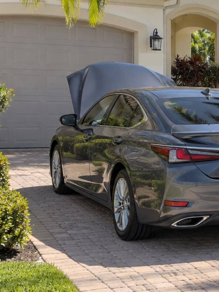 Mobile mechanic servicing a sedan in a driveway in South Naples, Florida