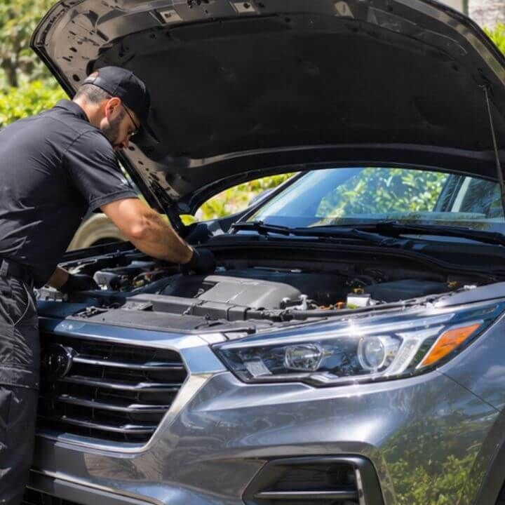 Mobile mechanic servicing an SUV at a residence in East Naples, Florida.