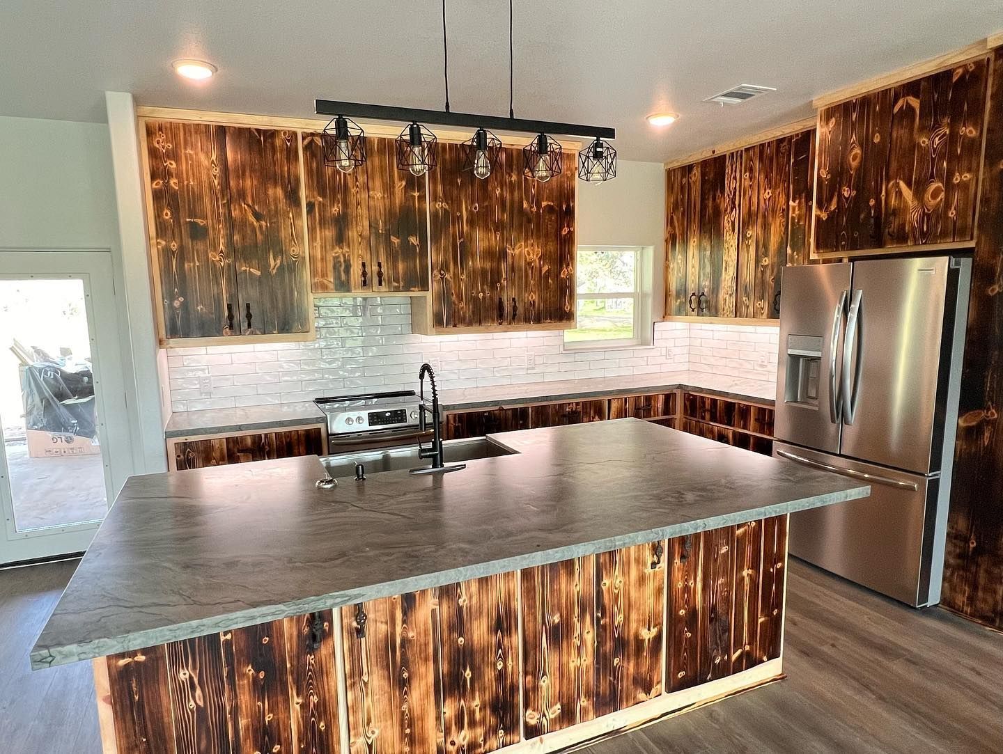 A kitchen with stainless steel appliances and wooden cabinets.