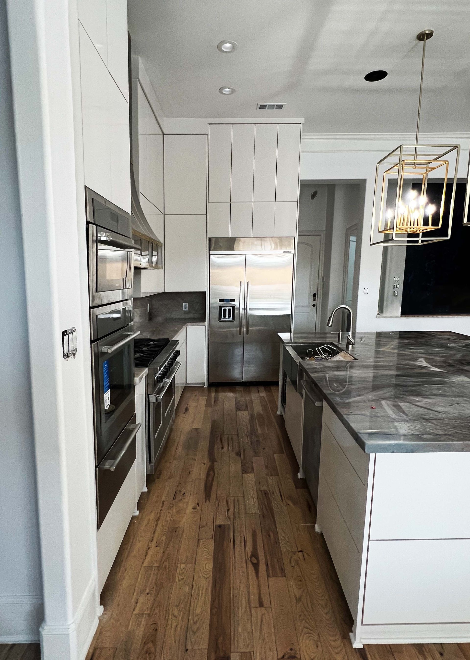 A kitchen with white cabinets and stainless steel appliances
