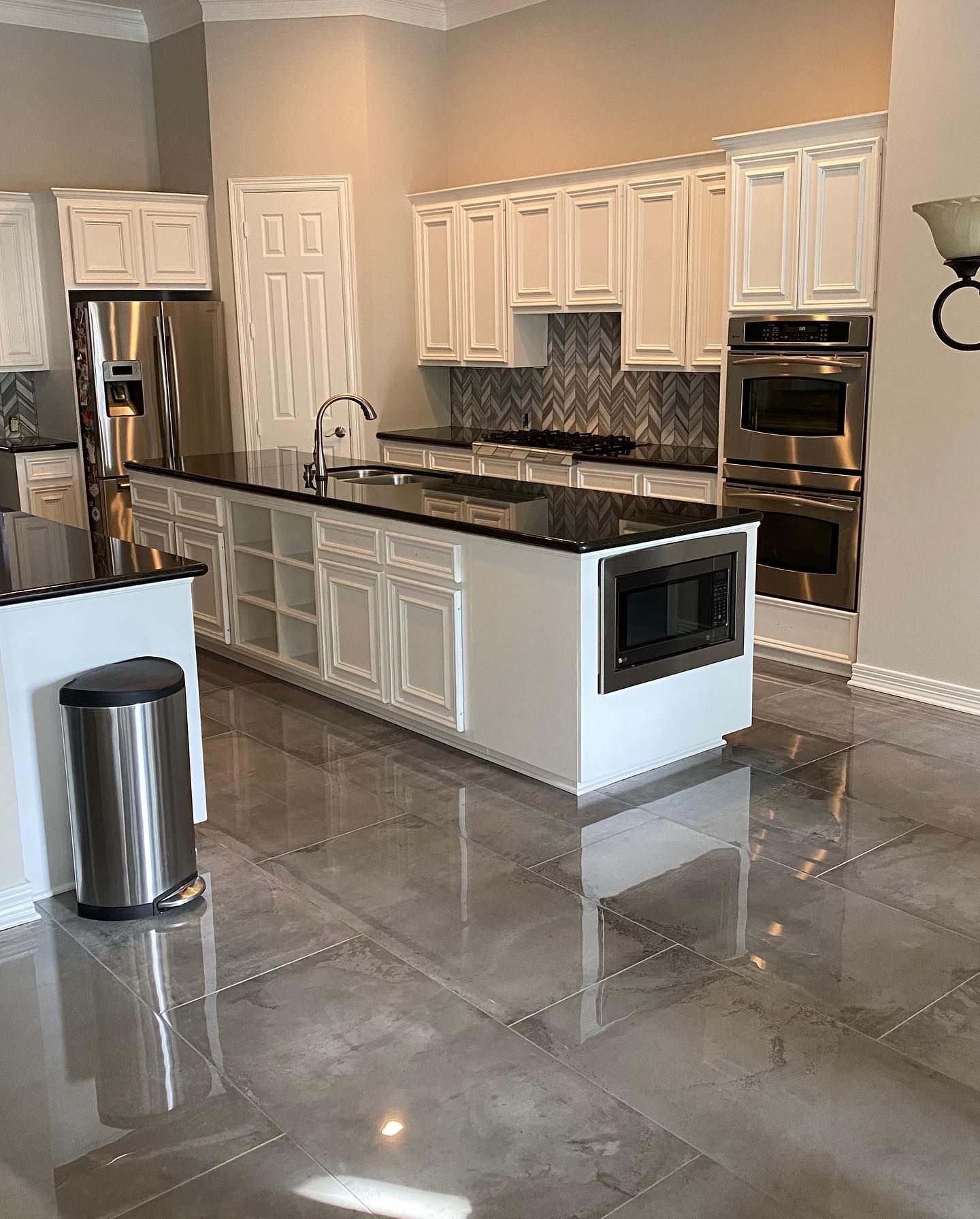A kitchen with white cabinets and stainless steel appliances