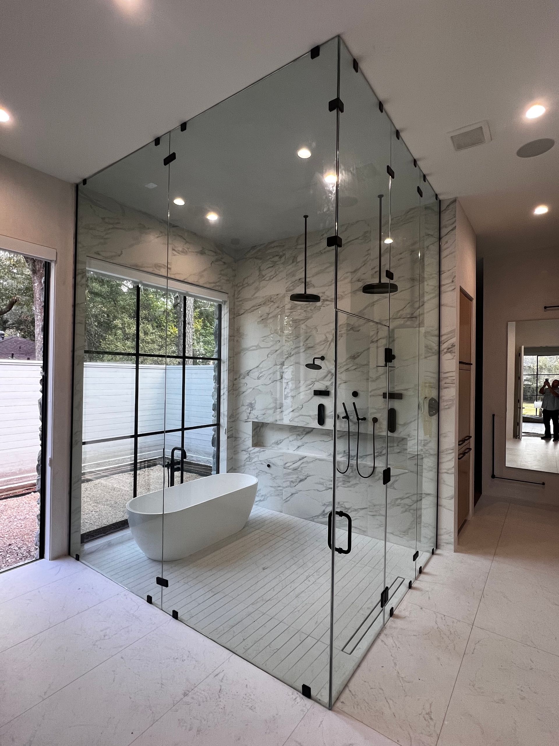 A bathroom with a bathtub and a shower stall with glass doors.