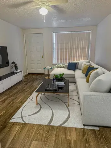 Photo of a living room with the front door area in the background