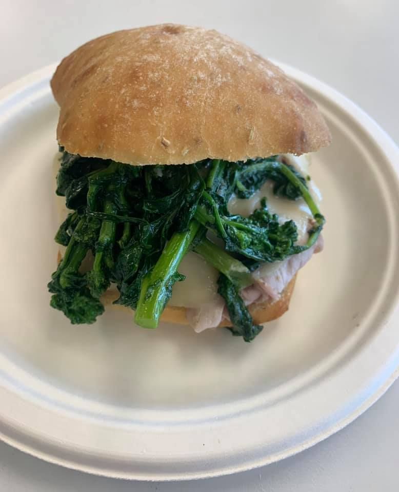 Sandwich with leafy greens on a white plate