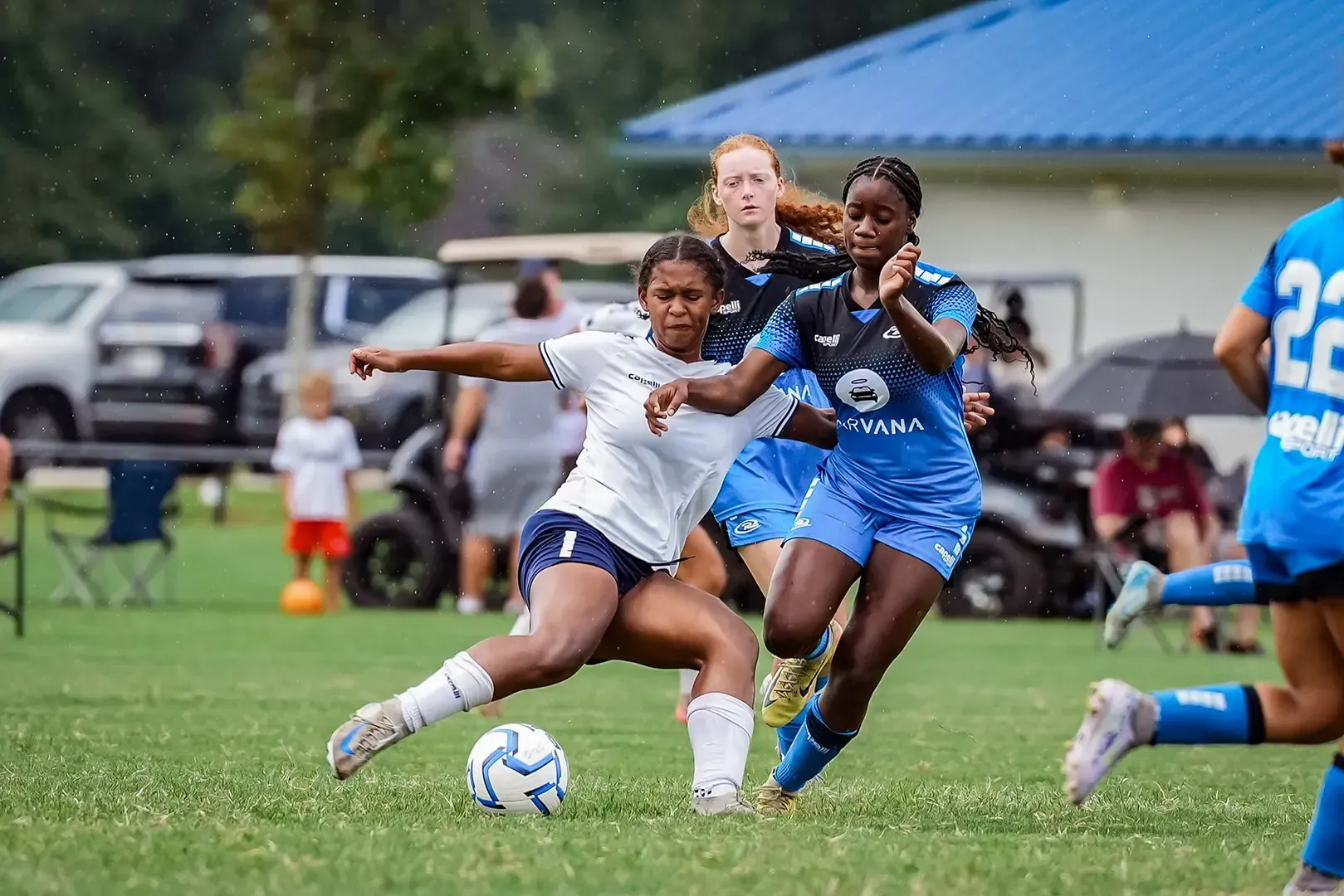 Two soccer players competing for the ball on a green field during a game.