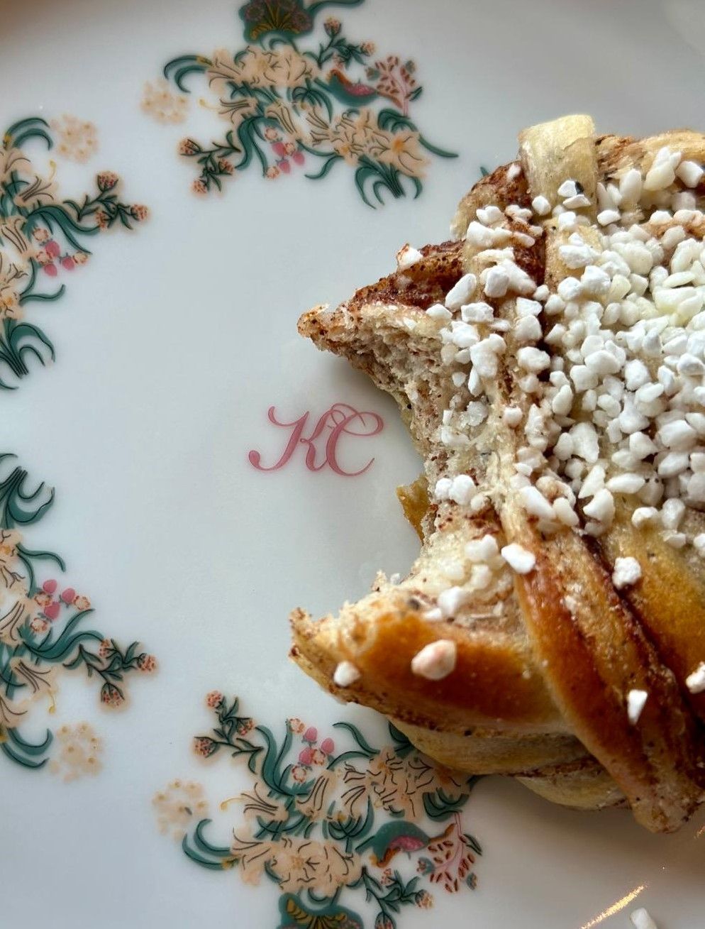 Powdered pastry on a floral plate with a pink monogram