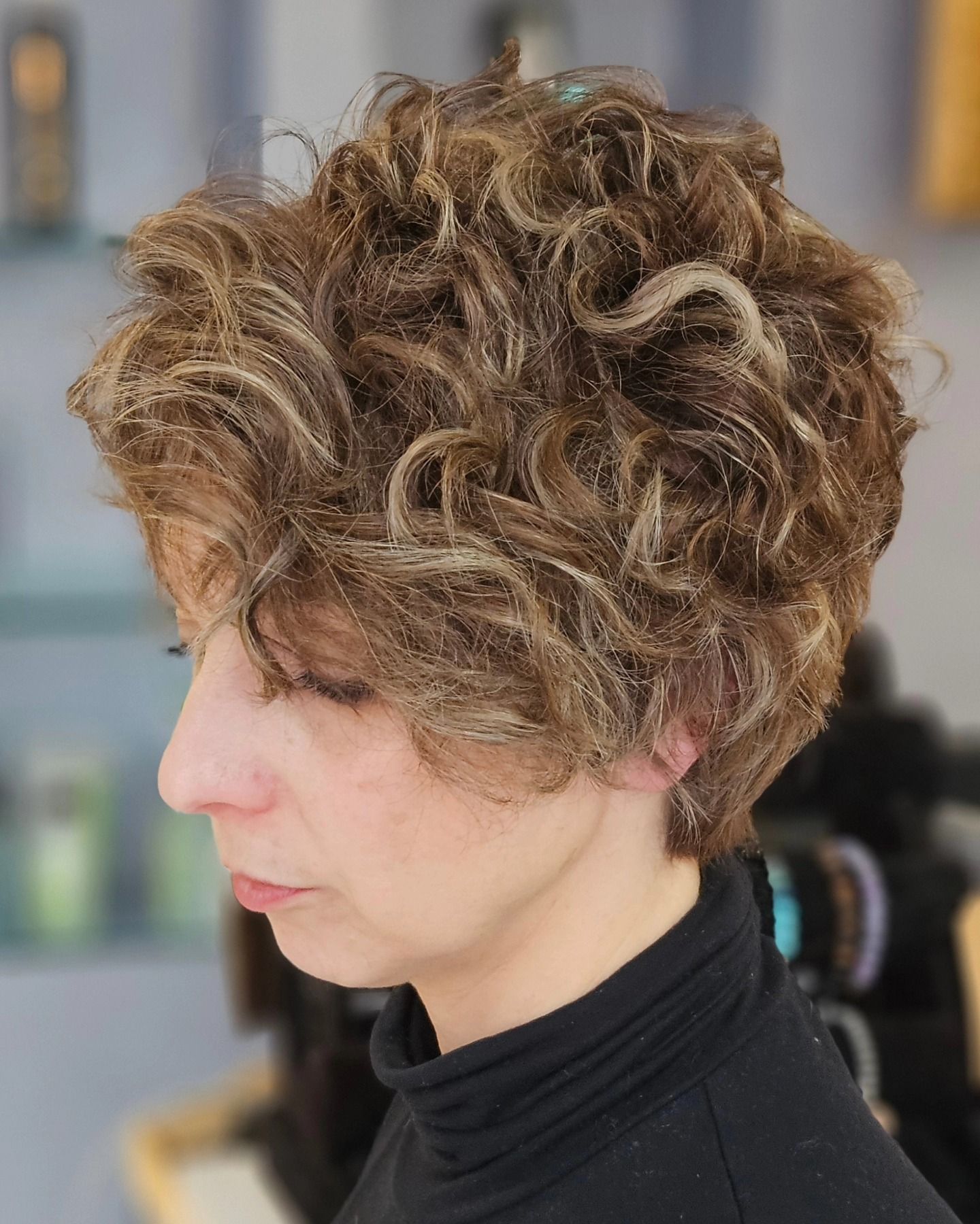 Una donna con i capelli ricci indossa un dolcevita nero