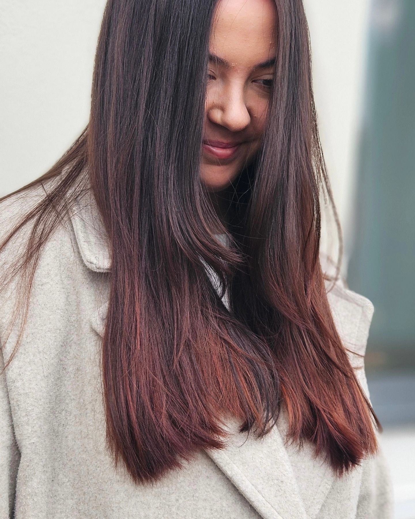 Una donna con lunghi capelli castani indossa un camice bianco