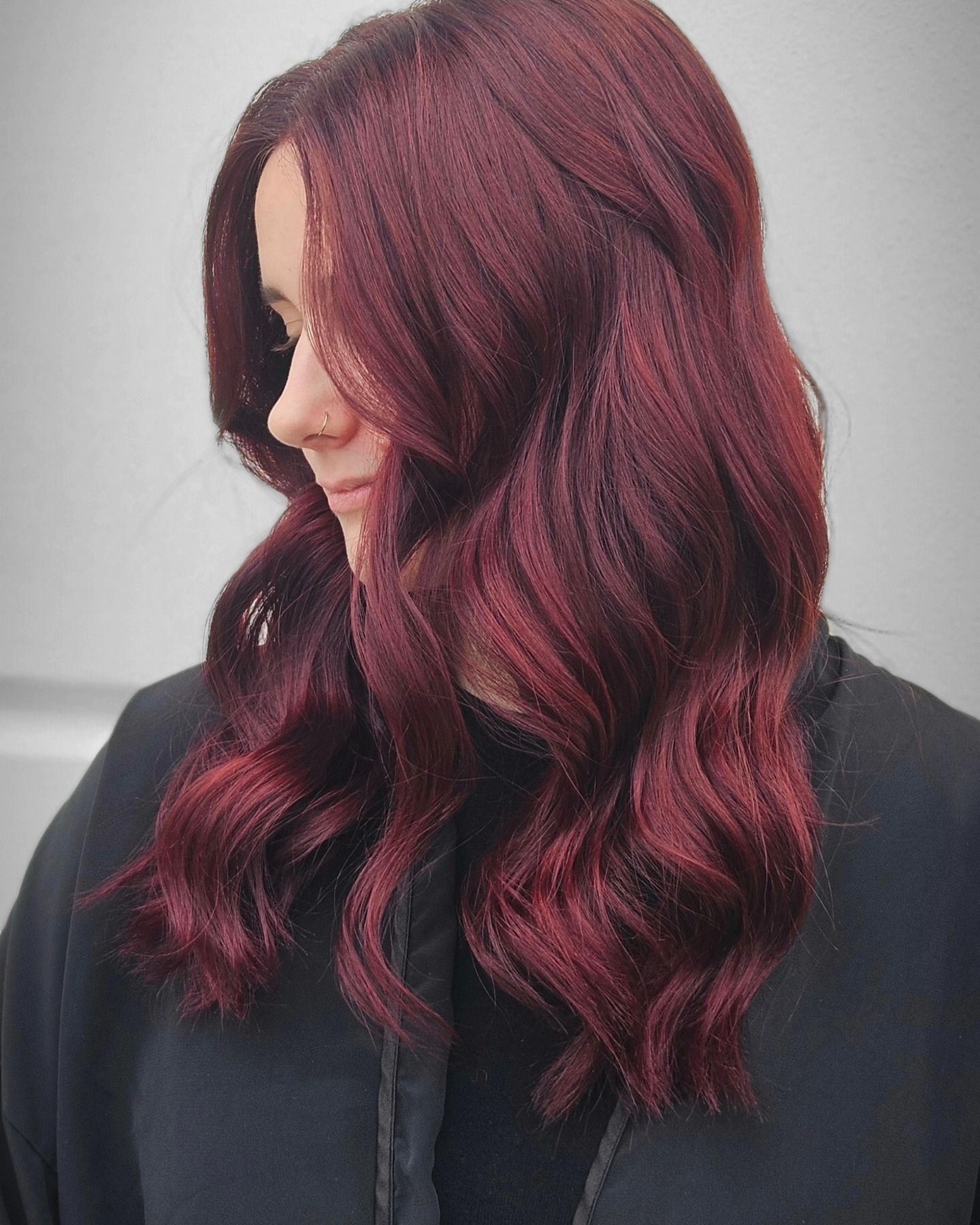 Una donna con lunghi capelli rossi indossa una giacca nera.