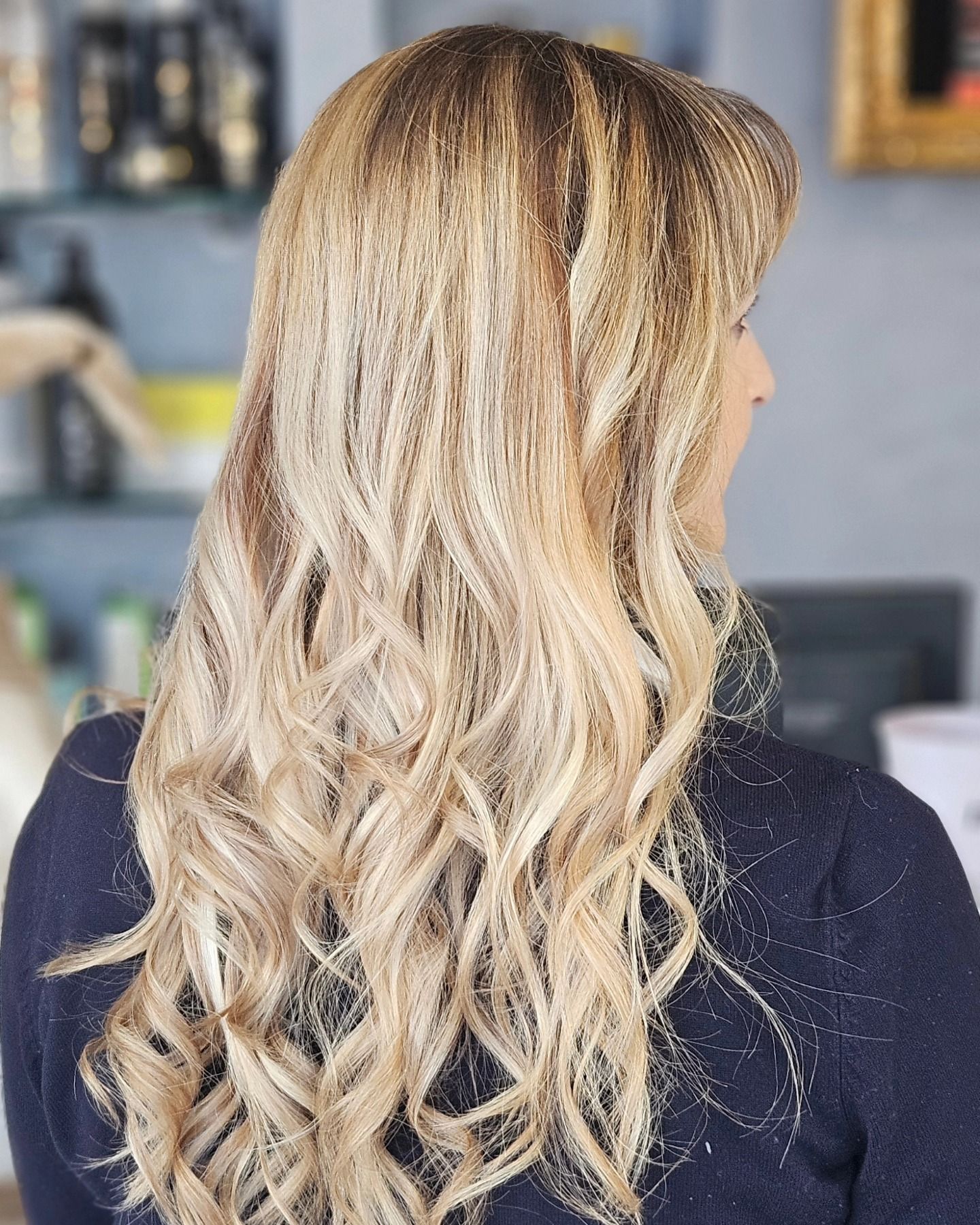 Una donna con lunghi capelli biondi indossa un maglione nero