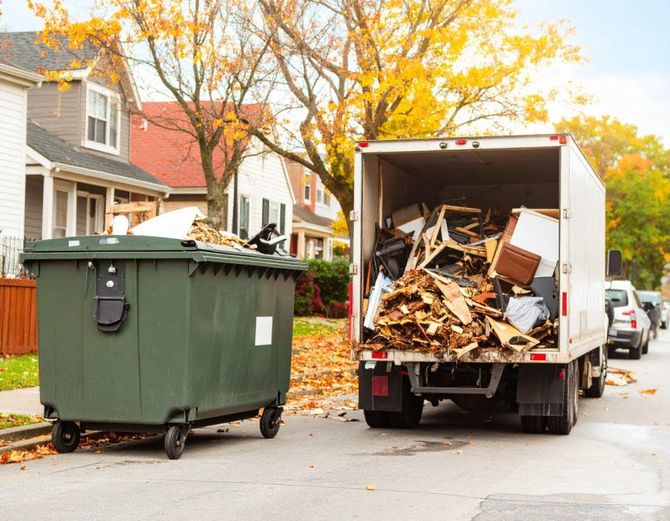 Dumpster and overflowing moving truck on a suburban street in autumn