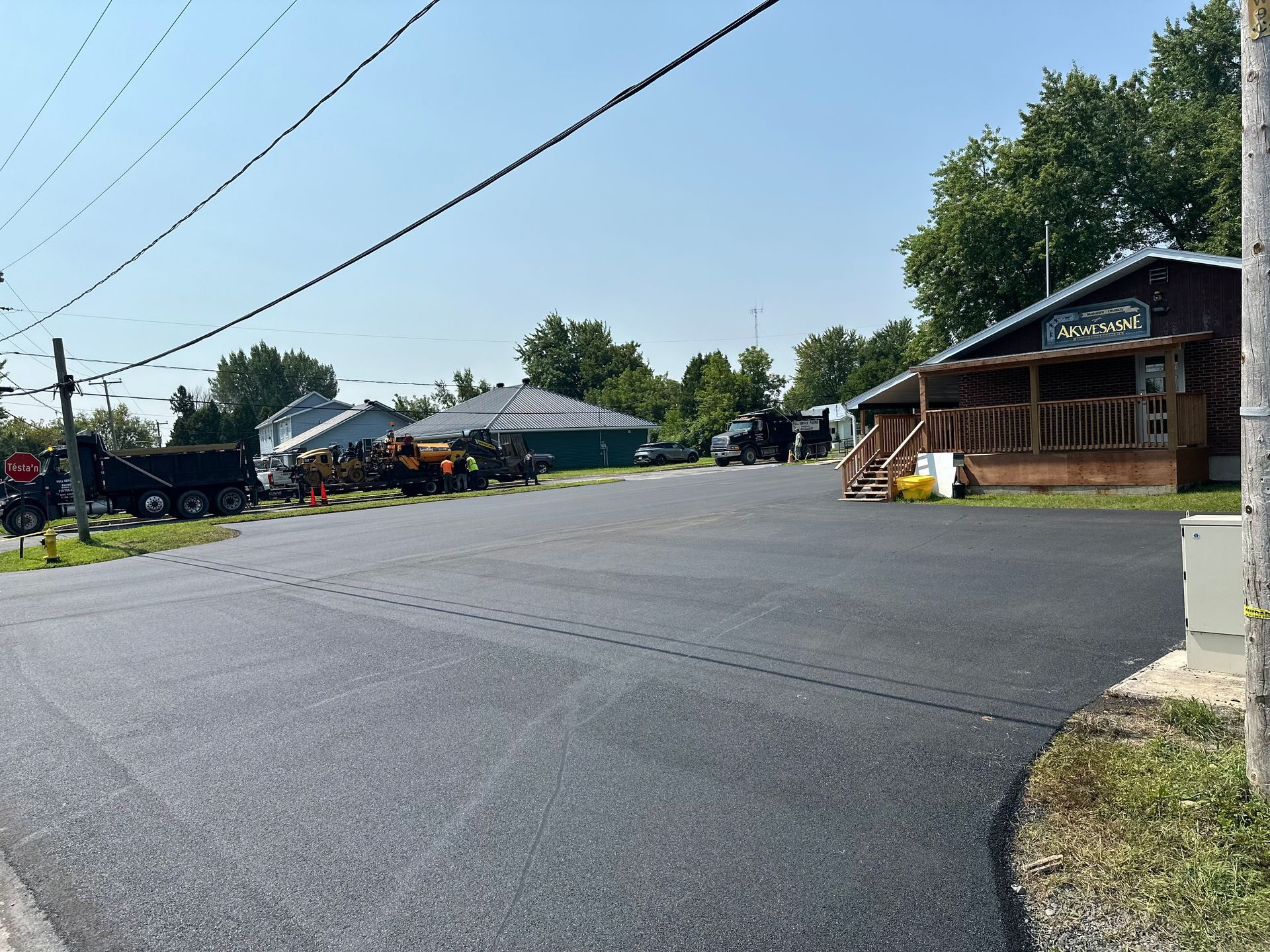 A lot of vehicles are parked on the side of the road in front of a building.