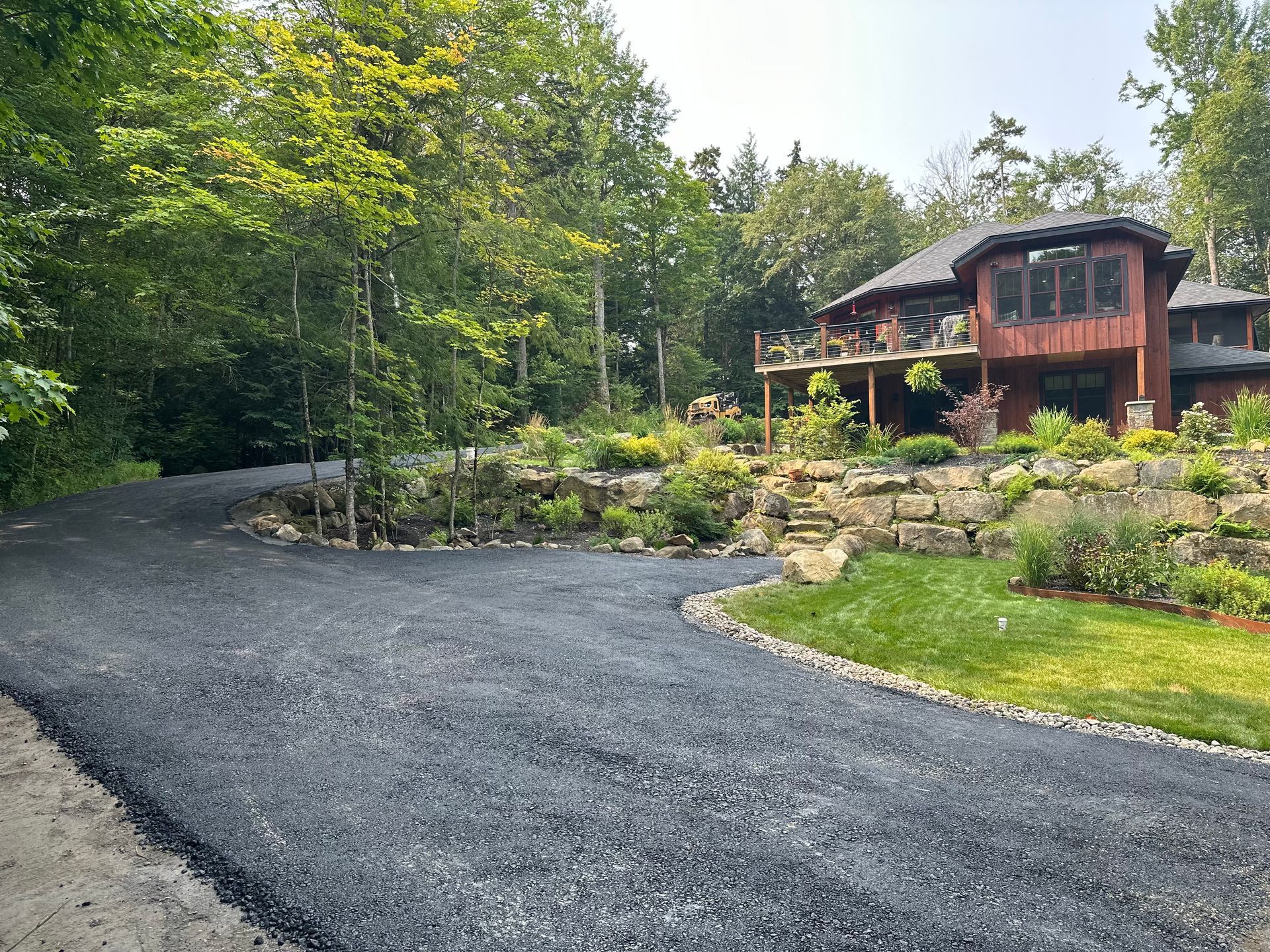 A driveway leading to a large house surrounded by trees.
