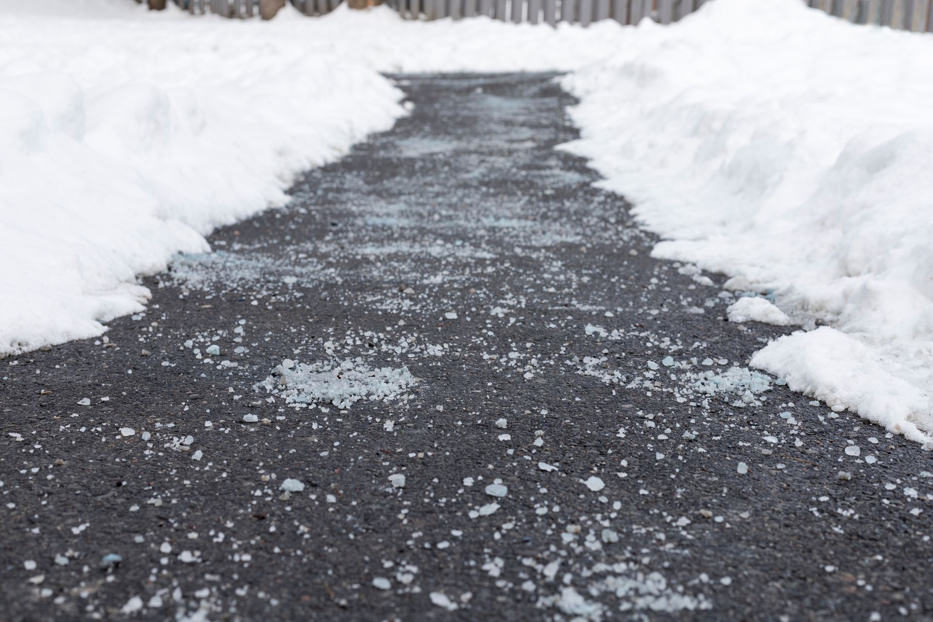 A snowy sidewalk with a lot of snow on it.