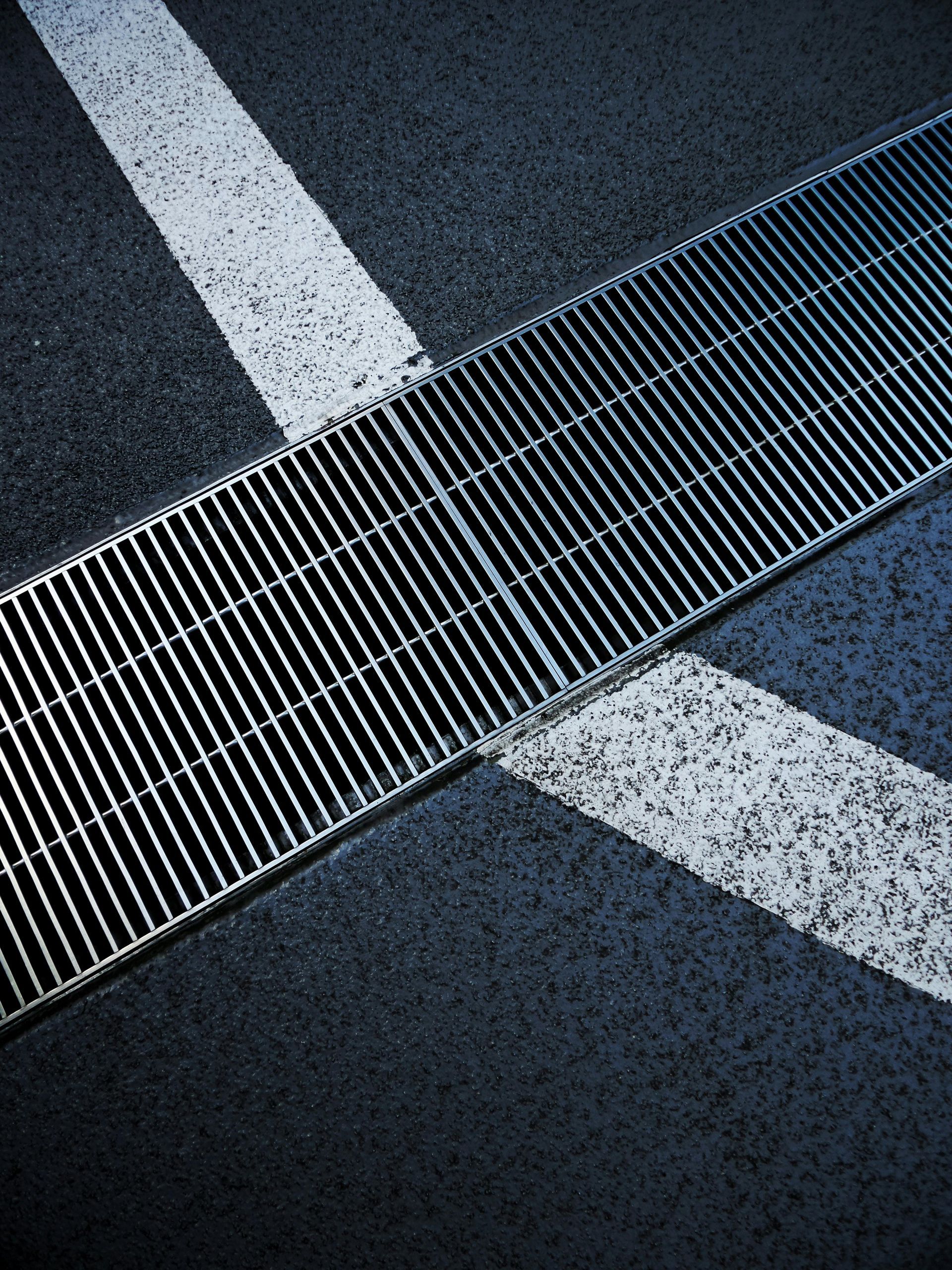 A metal grate on the side of a parking lot