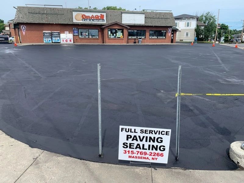 A sign that says full service paving sealing in front of a store