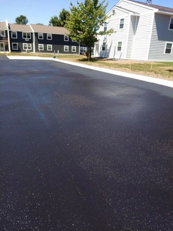 A parking lot with a house in the background