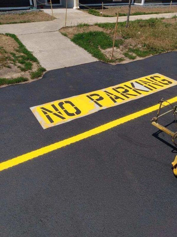 A no parking sign is painted on the road