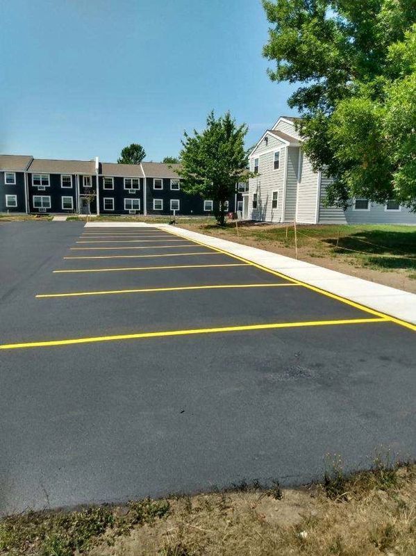 A parking lot with yellow lines in front of a building