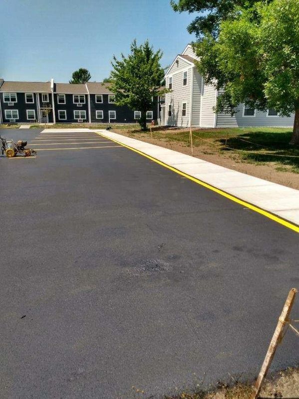 A road with a yellow line on it and a building in the background