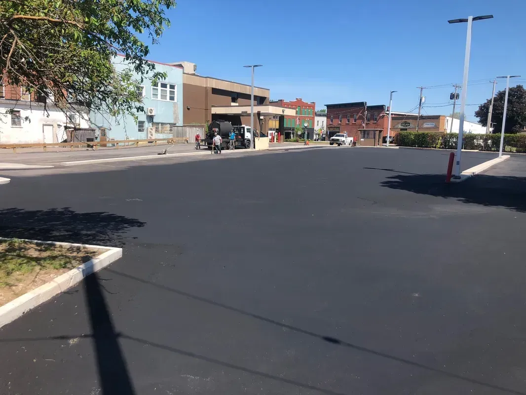 A parking lot with a lot of cars parked on the side of the road.