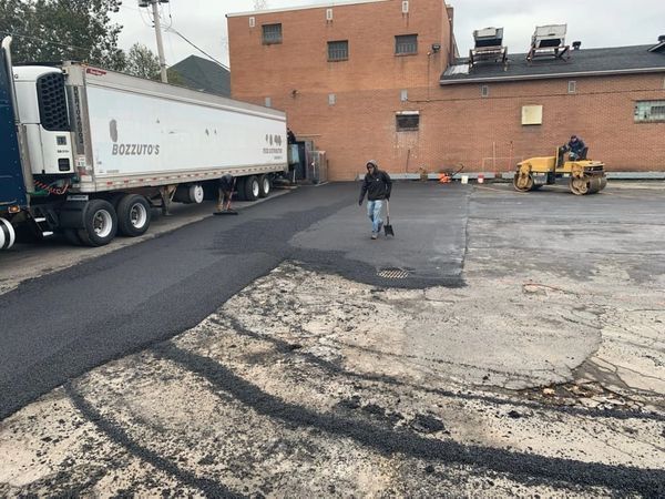 A man is walking down a road next to a truck.